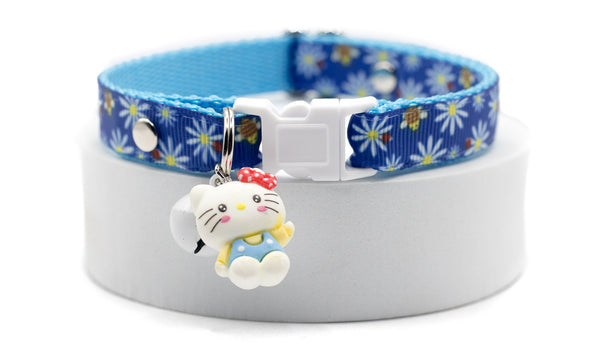 Cat collar with blue floral pattern and cartoon character charm on a white background