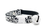 Cat collar with black and white paw pattern and bell on a white background