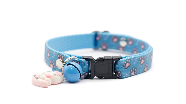 Blue cat collar with paw print pattern on a white background