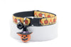 Halloween-themed cat collar with pumpkins and a jack-o'-lantern charm on a white background