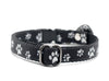 Black puppy collar with white paw print pattern on a white background
