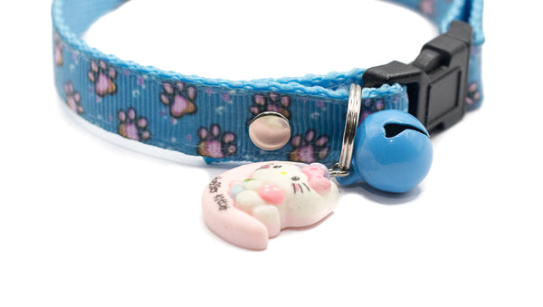 Blue cat collar with a pink cat charm and bell on a white background