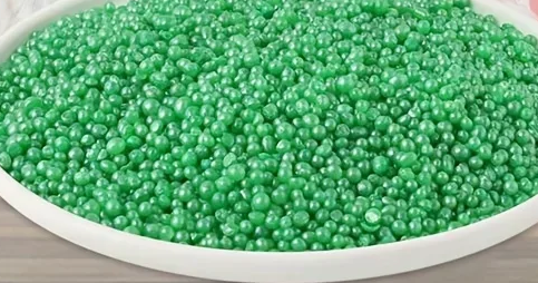 Green beads in a white bowl on a wooden surface